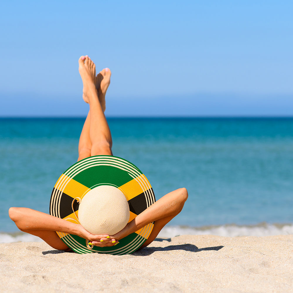 Woman with Jamaican flag sunhat on the beach