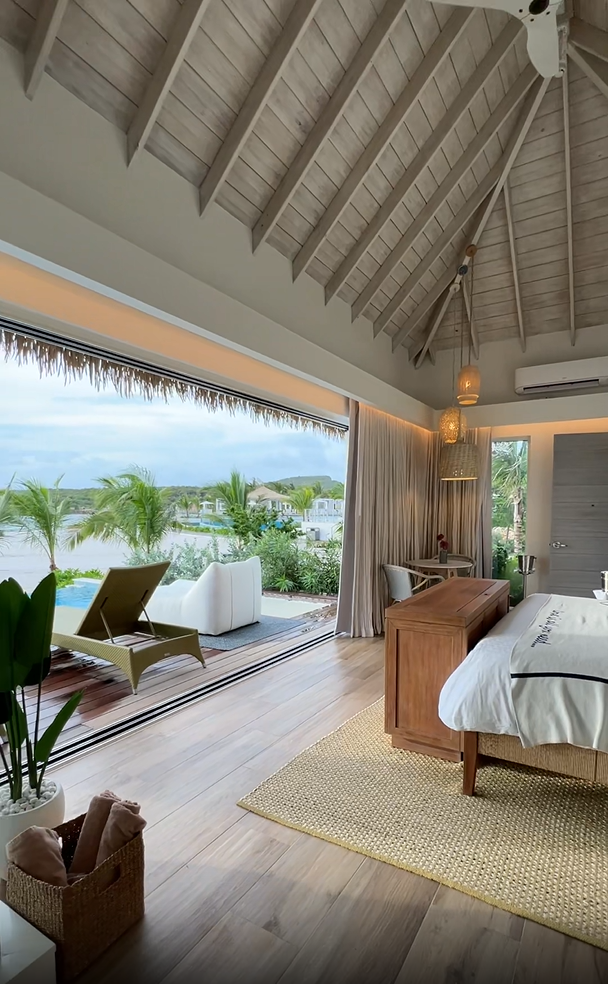 Sandals Royal Curaçao Awa Seaside Bungalow interior showing vaulted ceilings and open wall to private pool and deck