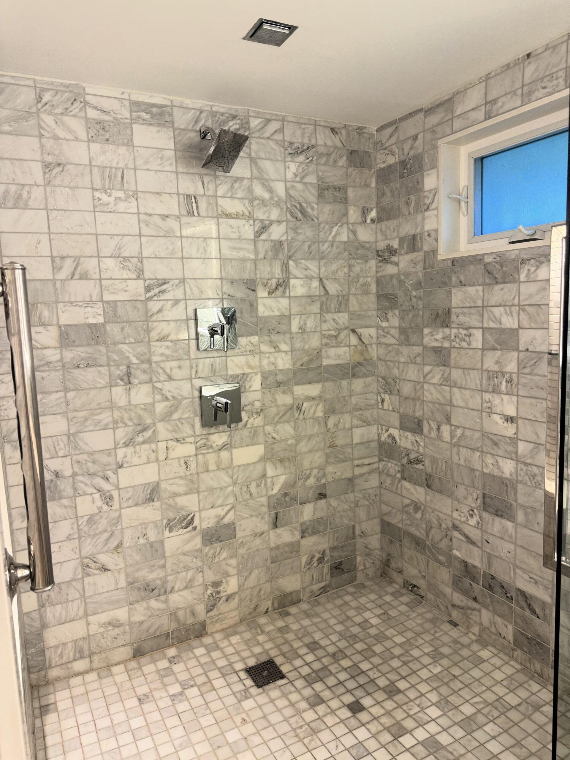 Large marble-tiled walk-in rain shower in the Sandals Royal Bahamian Island Village One Bedroom Walkout Butler Villa Suite bathroom