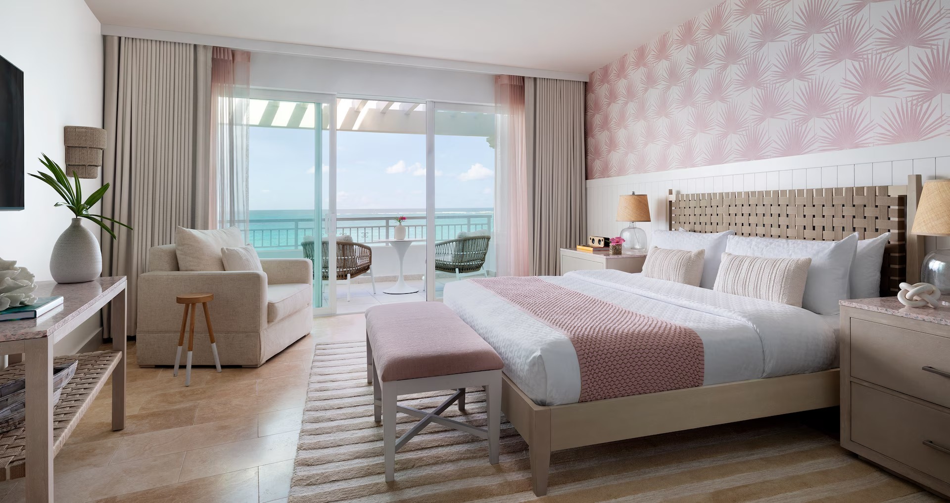 Bedroom in the East Bay Beachfront Club Level Room (BC) at Sandals Royal Bahamian, with a king bed, seating area, and oceanfront balcony