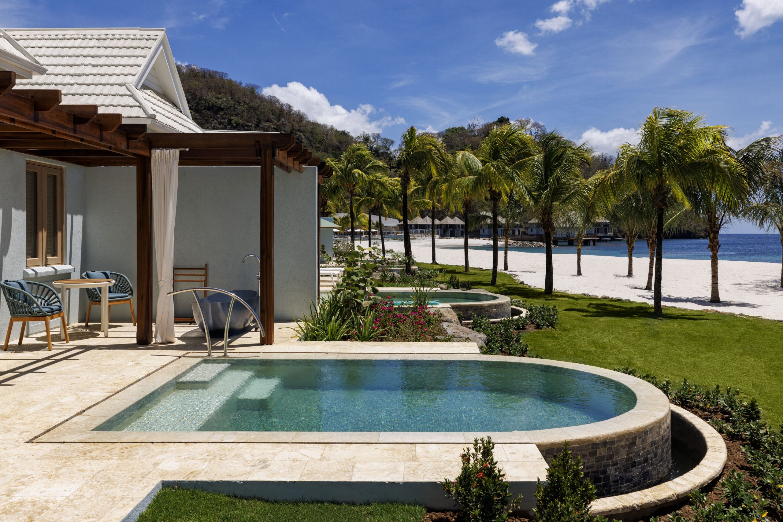 Exterior of the Beachfront One-Bedroom Butler Villa Suite with Private Pool (BVJP) at Sandals Saint Vincent, with a pergola, seating area, plunge pool, soaking tub.