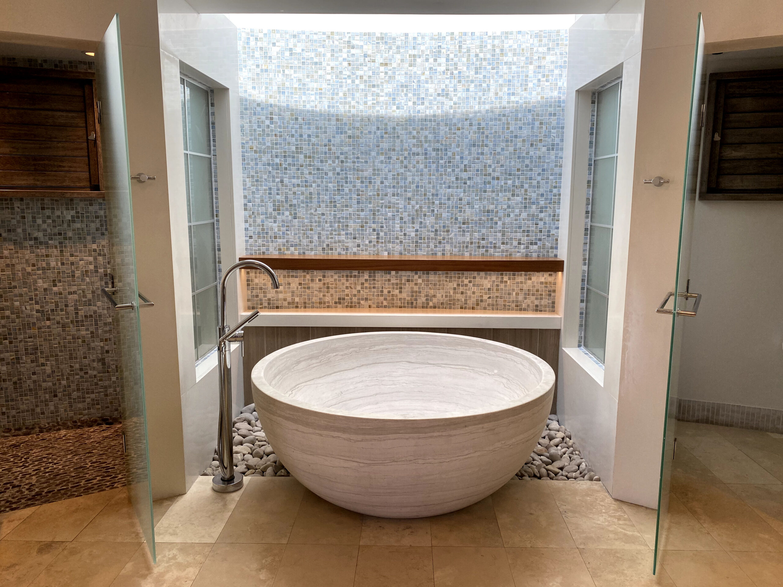 Spa bathroom in the South Seas Royal Rondoval Butler Suite (RPP) at Sandals Royal Barbados, built around a round stone soaking tub with his-and-her vanities