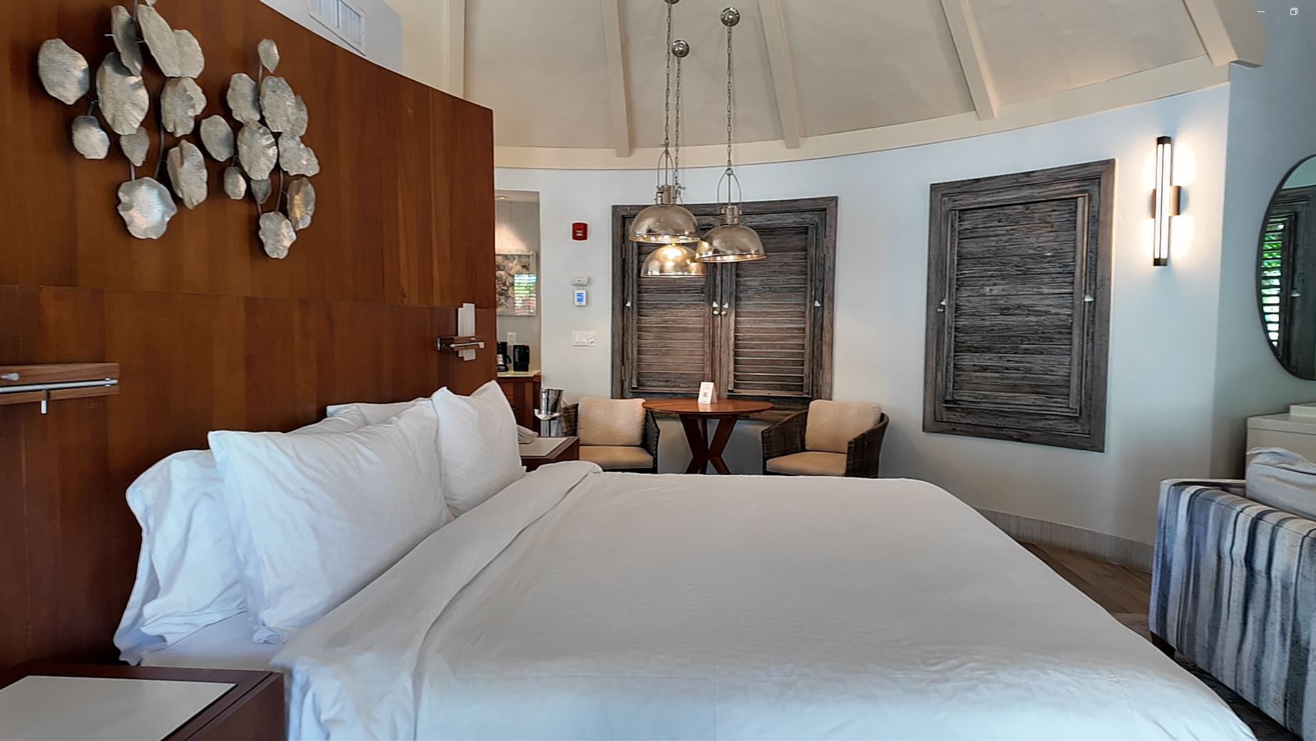 Bedroom inside the South Seas Royal Rondoval Butler Suite with Private Pool Sanctuary (RPP) at Sandals Royal Barbados, with a mahogany king bed under a 20-foot conical thatched ceiling