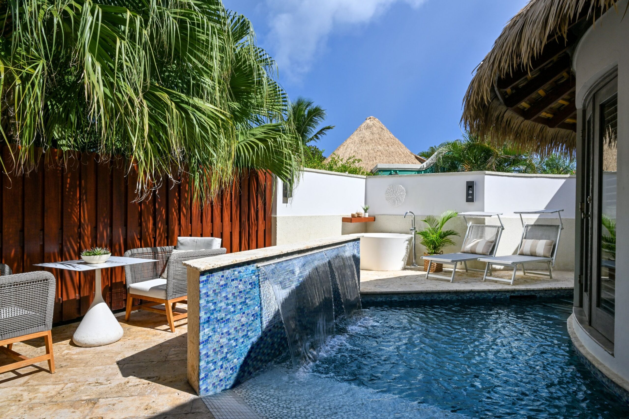 Private patio and zero-entry plunge pool with a waterfall feature, loungers, and a soaking tub at the South Seas Royal Rondoval Butler Suite (RPP) at Sandals Royal Barbados