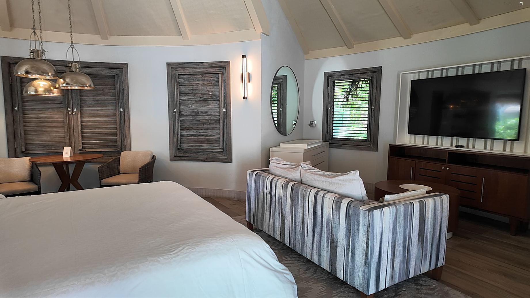 Living area in the South Seas Royal Rondoval Butler Suite (RPP) at Sandals Royal Barbados, with a striped sofa, smart TV, and the round open layout