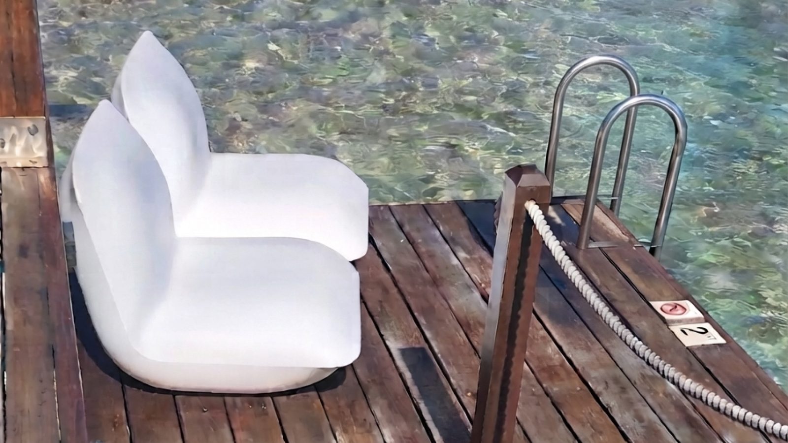 Overwater Honeymoon Butler Bungalow (OWB) patio at Sandals Grande St. Lucian with loungers and steps into the Caribbean