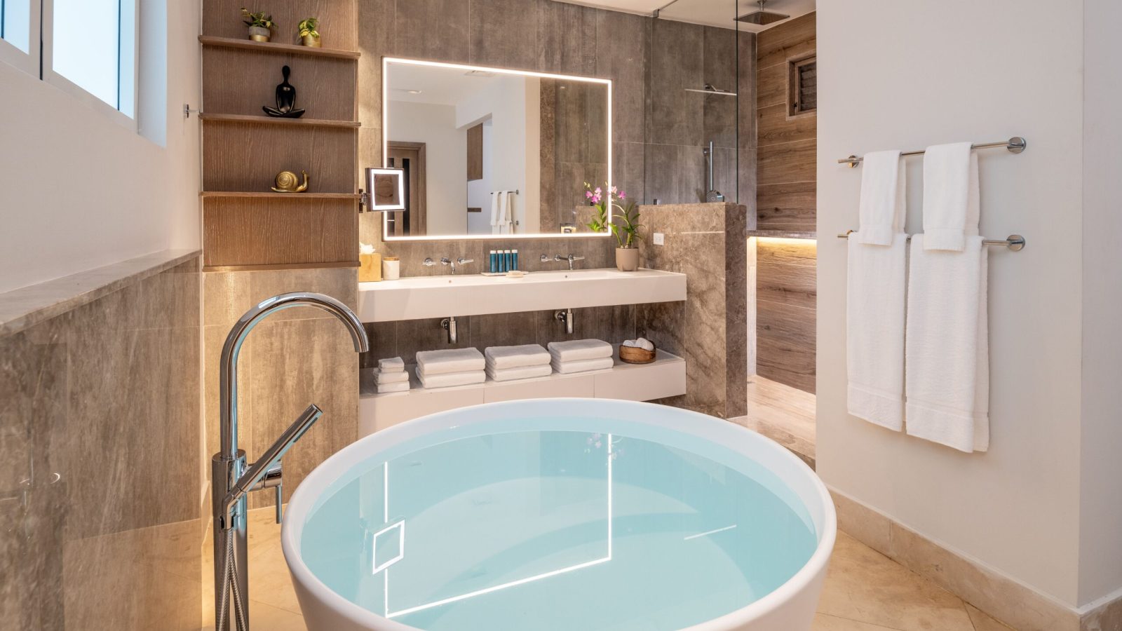 Sandals Dunn's River Tufa Terrace Swim-Up Butler Suite bathroom with accent lighting, light wood, rain shower and soaking tub