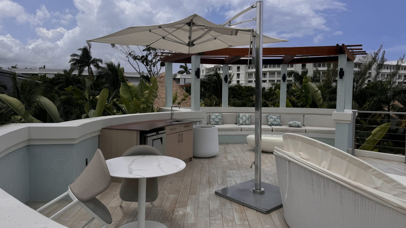 Private rooftop deck with a wet bar, seating, and shade at the Coyaba Sky Villa Rondoval Butler Suite (SKYV) at Sandals Dunn's River