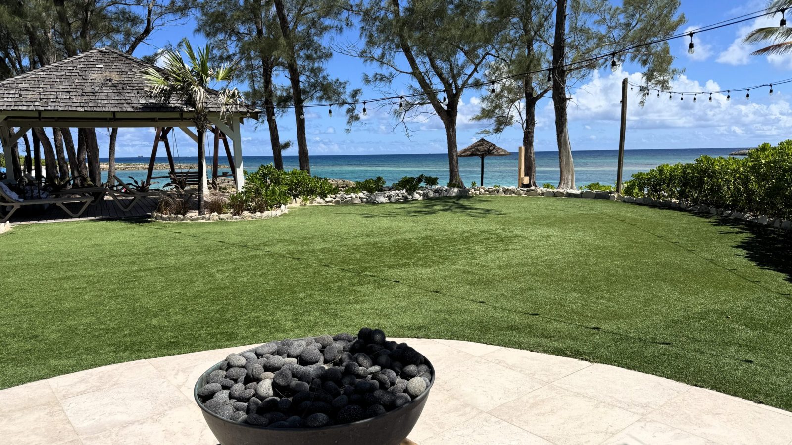Zen garden lawn with gazebo, fire bowl, and ocean views on Sandals Barefoot Cay at Sandals Royal Bahamian