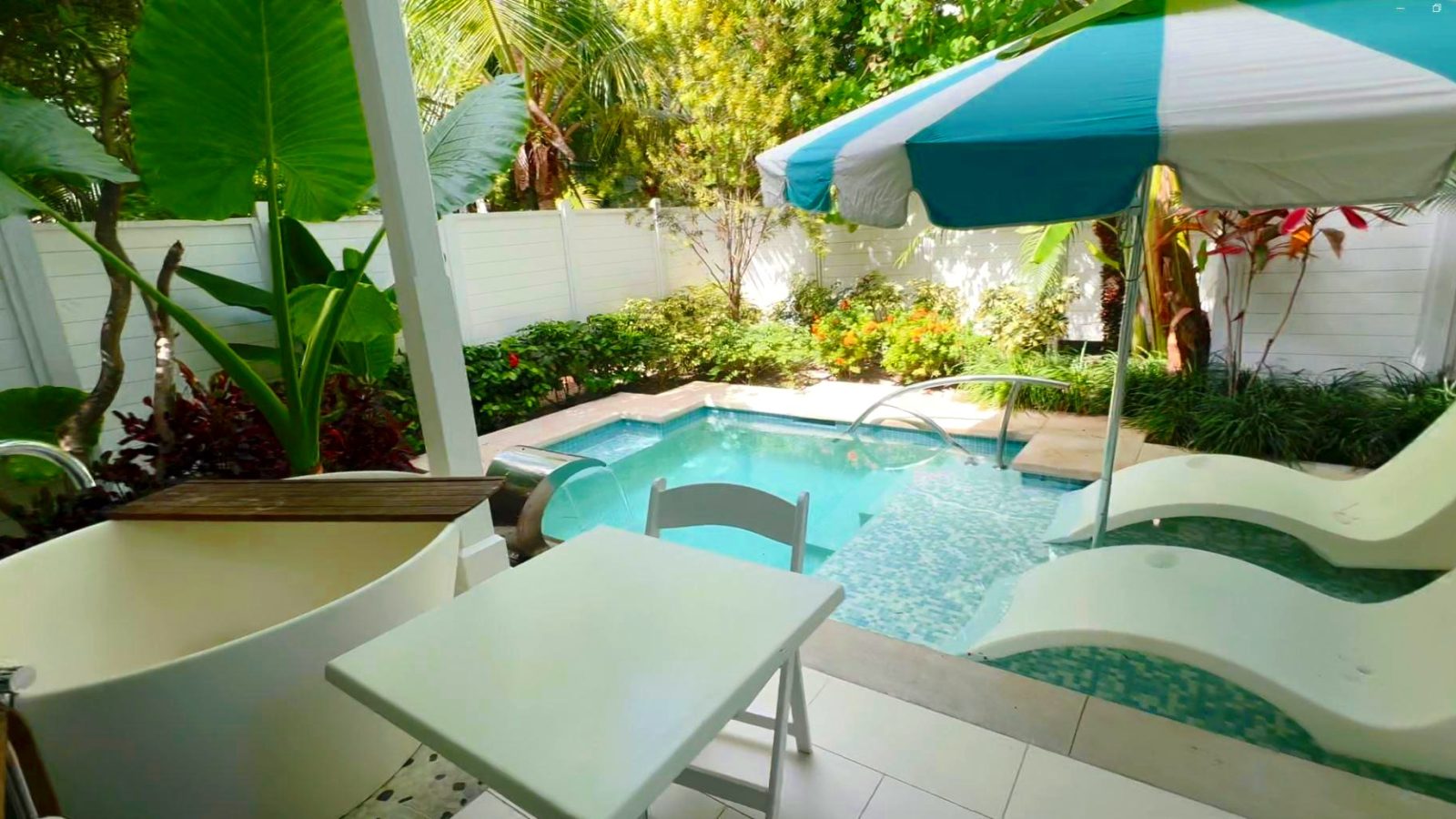 Fenced garden patio with the plunge pool, soaking tub, and shaded loungers at the Island Village One Bedroom Butler Villa Suite (V1PP) at Sandals Royal Bahamian