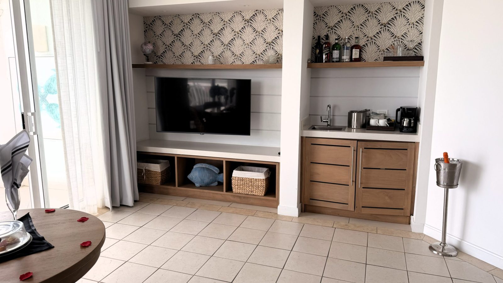 Stocked bar and kitchen area with sink and coffee maker in the Sandals Royal Bahamian West Bay Honeymoon Hideaway Oceanview One Bedroom Butler Suite living room